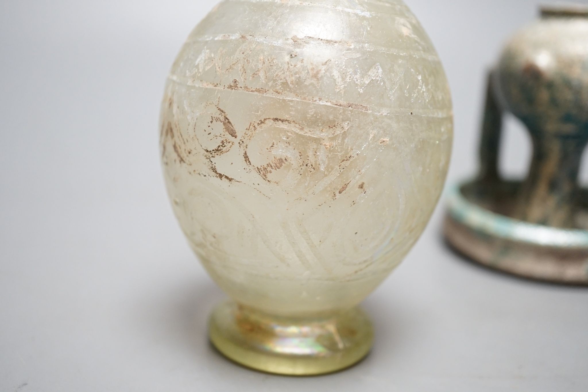 A Kashan oil lamp, 13th/14th century, and an early Islamic glass bottle., Bottle 22 cms high.